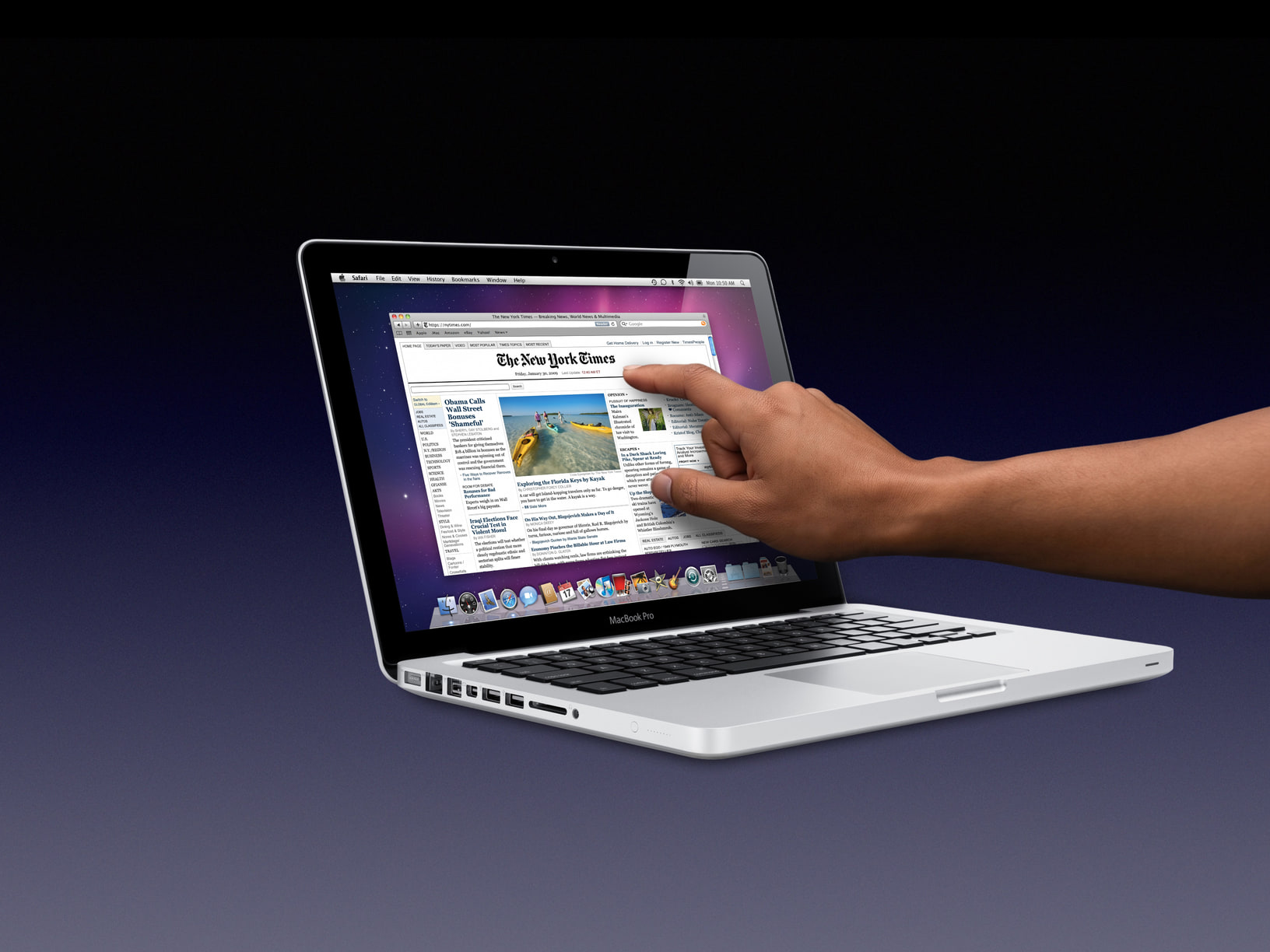A hand reaching up to touch the screen of a silver MacBook Pro, which is showing The New York Times home page in Safari, against a dark blue gradient