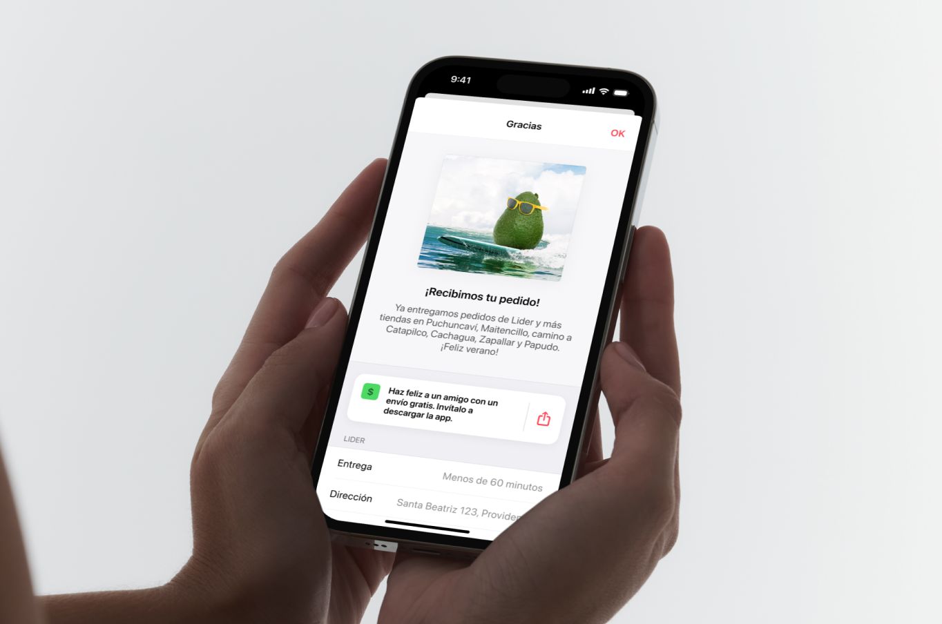 Two hands holding an iPhone on the screen that follows an order: an avocado in sunglasses surfing a wave, over “¡Recibimos tu pedido!” and a note that Cornershop now delivers to the towns up the coast.